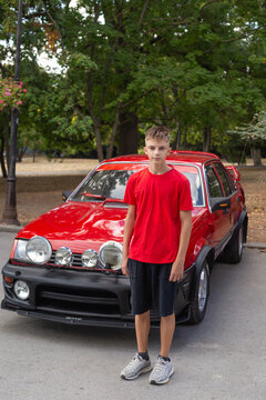 boy in car. a teenager with a classic red car