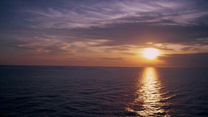 sun setting over the ocean. A sunset over the ocean with a horizon of water. Beautiful nature with a serene sky. ", the sun descending beyond the sea. Lifestyle.