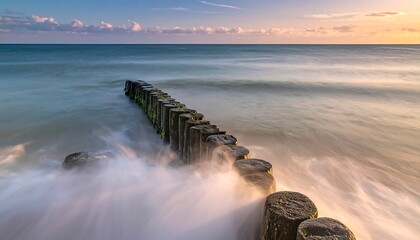 Calm sea waves crashing against a breakwater at sunset