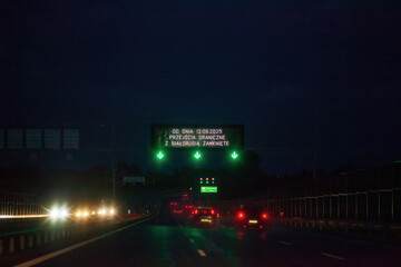 Electronic billboard message about closed border on night highway with Belarus in Krakow, Poland