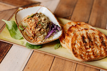 Savory dish with toast on wooden board. Pâté, puree or foie gras serving.