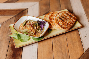 Savory dish with toast on wooden board. Pâté, puree or foie gras serving.
