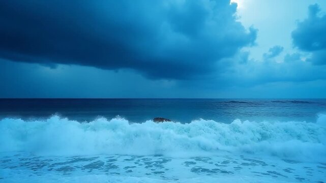 A stormy sea with crashing blue waves under dark clouds near the coast of Budva Montenegro. The powerful ocean swells and dramatic sky create a breathtaking display of natures force.