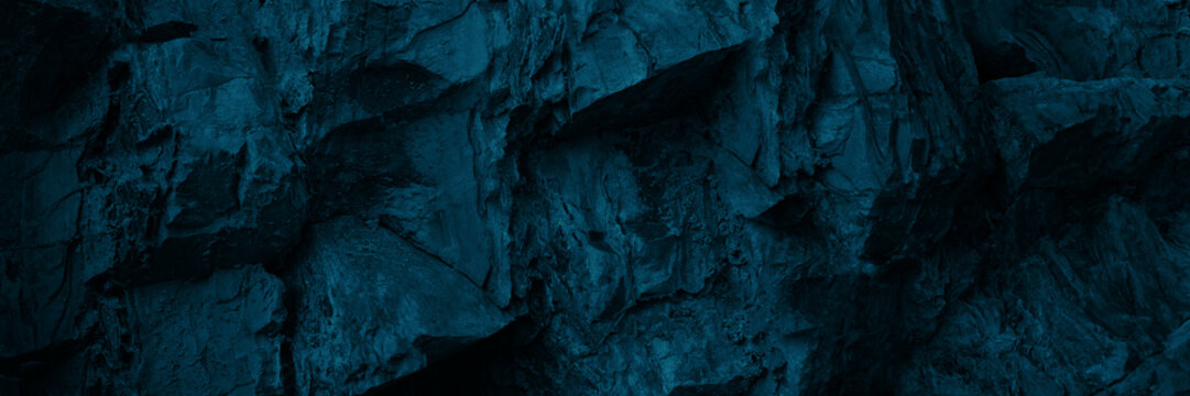 Black dark blue turquoise stone rock texture background. Toned rocky surface mountain. Close-up. Nature. For design. Wide banner. Panoramic.