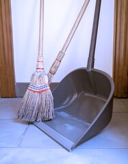 Broom and dustpan on tiled floor