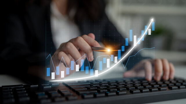 A close-up of a professional hand conducting a financial analysis using data charts and keyboard in an office, representing growth, investment strategies, and technology. Impute