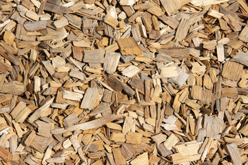 Natural wood mulch texture, consisting of various sizes of shredded bark and wood chips, creating a warm earthy appearance suitable for landscaping and gardening projects