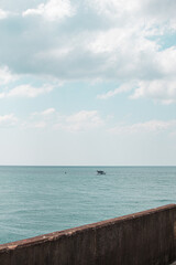 Obraz premium View of the calm sea at Brighton with a boat on the water under a cloudy sky