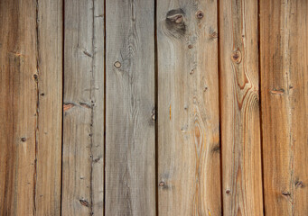 Textured wooden planks in varying shades of brown and gray, showcasing natural grain patterns and knots, creating a rustic and warm atmosphere for design purposes