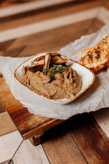 Luxury foie gras pâté on wooden board. Gourmet French delicacy served with herbs.