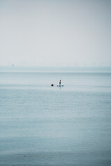 Stand-up paddleboarding on a calm sea near Brighton, capturing the serene morning atmosphere