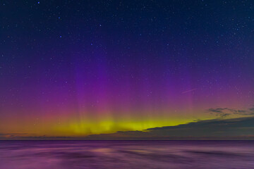 Northern lights over the Baltic Sea at night, colorful aurora borealis with stars in the sky, Poland