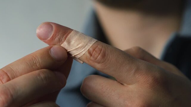 Protective medical tape on an injured finger.
Adhesive tape to protect an open wound from infection.
A wound on the hand and an adhesive bandage on it.