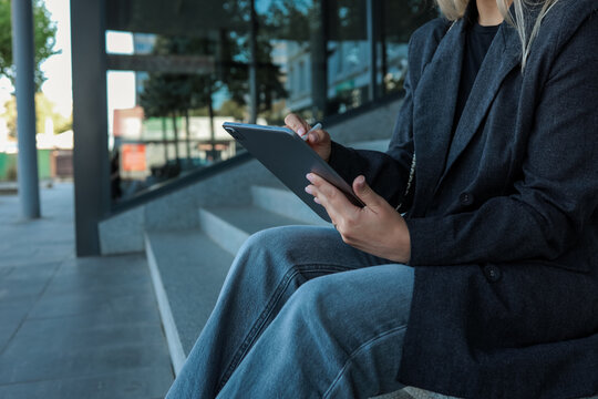 Woman working on a tablet outdoors - Powered by Adobe