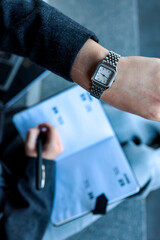 Person wearing a watch while writing in a notebook