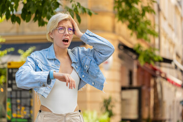 Scared woman worrying to be punctual, with anxiety checking time on watch, running late to work or...