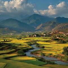 A tranquil valley scene unfolds, showcasing a meandering river cutting through vibrant yellow rice paddies, nestled amidst verdant hills and a majestic mountain backdrop under a partly cloudy sky