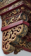Intricately carved wooden bracket, painted in red and gold, features swirling patterns, mythical creatures, and floral motifs.  The piece shows signs of age and wear, adding to its character