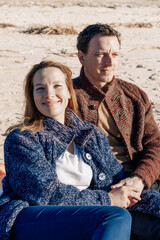 Portrait loving couple walks on beach along sea on sunny autumn day. Weekend and lifestyle concept. Vertical photo. High quality photo