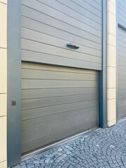 Fototapeta premium On a picturesque cobblestone street, a gray garage door stands wide open, allowing glimpses of the interior within