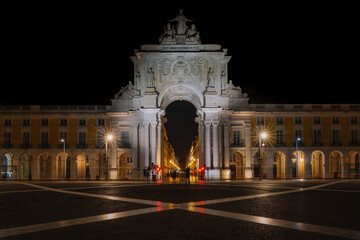 Fototapeta premium The illuminated Arco da Rua Augusta at night in Lisbon, Portugal. The triumphal arch on Praça do Comércio stands as a symbol of the city’s resilience and grandeur, beautifully lit against the dark sky