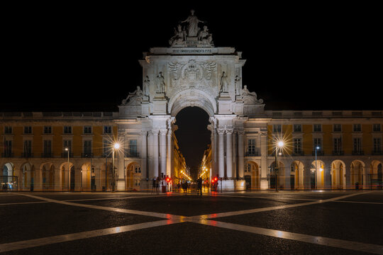 The illuminated Arco da Rua Augusta at night in Lisbon, Portugal. The triumphal arch on Pra&ccedil;a do Com&eacute;rcio stands as a symbol of the city&rsquo;s resilience and grandeur, beautifully lit against the dark sky