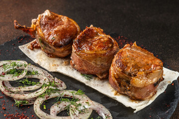 Pork medallions wrapped in bacon with onion and herbs