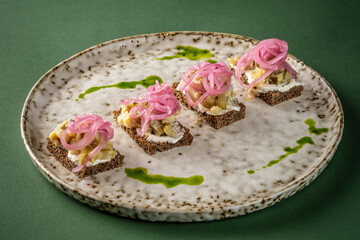 Rye bread canape with pickled onions and cream cheese