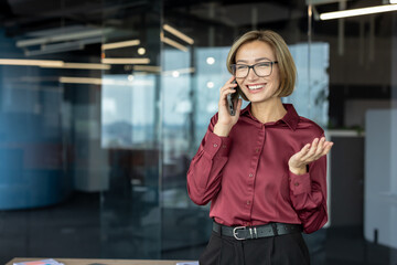Businesswoman smiling while talking on phone in office