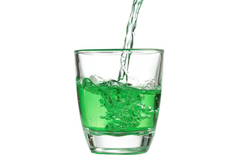Clear shot glass filled with vibrant green liquid, water pouring into it