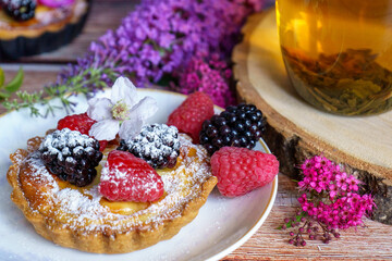 Tarts topped with fresh berries and dusted with powdered sugar. 