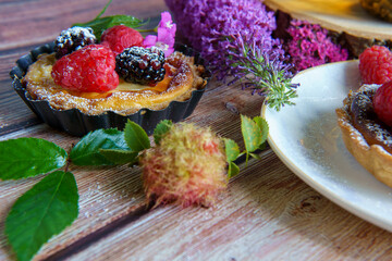 Tarts topped with fresh berries and dusted with powdered sugar. 