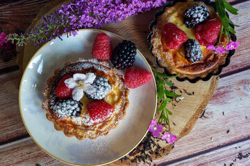 Tarts topped with fresh berries and dusted with powdered sugar. 