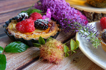 Tarts topped with fresh berries and dusted with powdered sugar. 