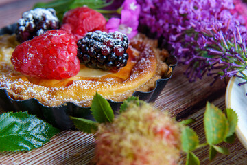 Tarts topped with fresh berries and dusted with powdered sugar. 