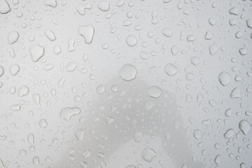 A wet surface with many small water droplets scattered across it