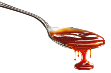 Spoonful of dark reddish-brown sauce dripping