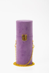A purple purse with a gold chain and a gold clasp. The purse is made of a soft material and has a chain that is attached to it