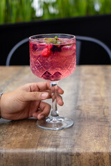 Bebida con alcohol y frutas sostenida