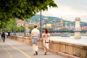 Naklejka premium Riverside promenade in old city, young couple walking