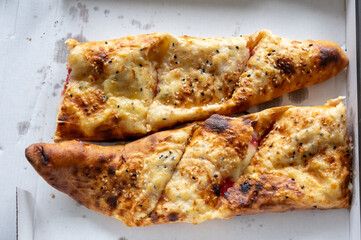 Two slices of pizza with cheese and sesame seeds