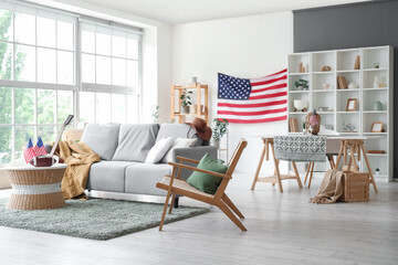 Interior of living room with grey sofa, USA flags and rugby ball on coffee table