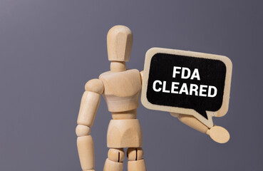 Concept of FDA Cleared write on sticky notes isolated on Wooden Table