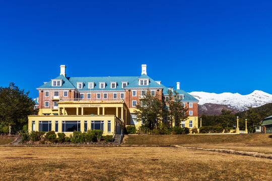 The historic Chateau Tongariro stands proudly against the snowy peaks of Mount Ruapehu in Tongariro National Park, New Zealand