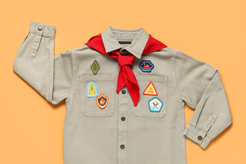 Scout uniform with badges on orange background