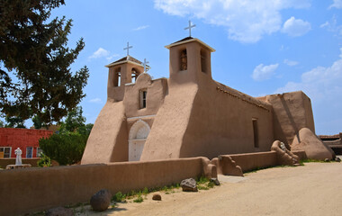 Fototapeta premium : side view of the picturesque, eighteenth century, adobe san francisco de asis mission church on a sunny summer day in ranchos de taos, new mexico