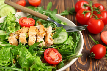 Composition with bowl of healthy arugula salad and ingredients on wooden background, closeup