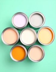 Paint cans in a circle of pastel colors on a mint green background