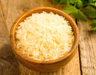 Wooden bowl of uncooked rice on a rustic table