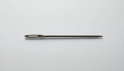A metal sewing needle lies flat, angled slightly, against a plain white background